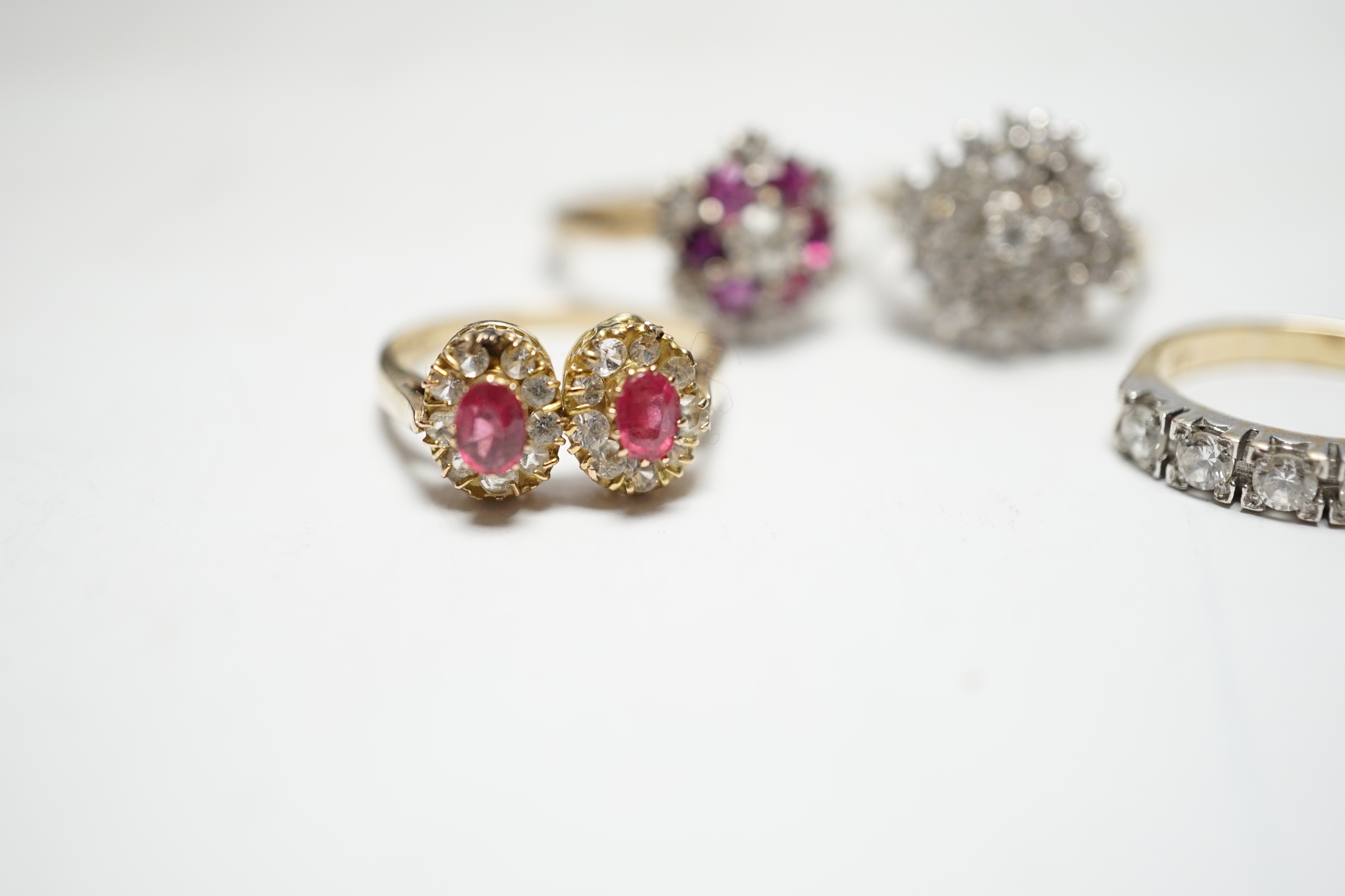 A modern 9ct gold, ruby and simulated diamond cluster set flower head ring, size N and three other assorted 9ct rings including CZ and two colour paste, gross weight 12.4 grams.